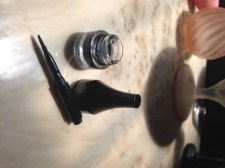 The lid is opened into two parts, displaying the brush. 